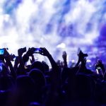 Hand with a smartphone records live music festival